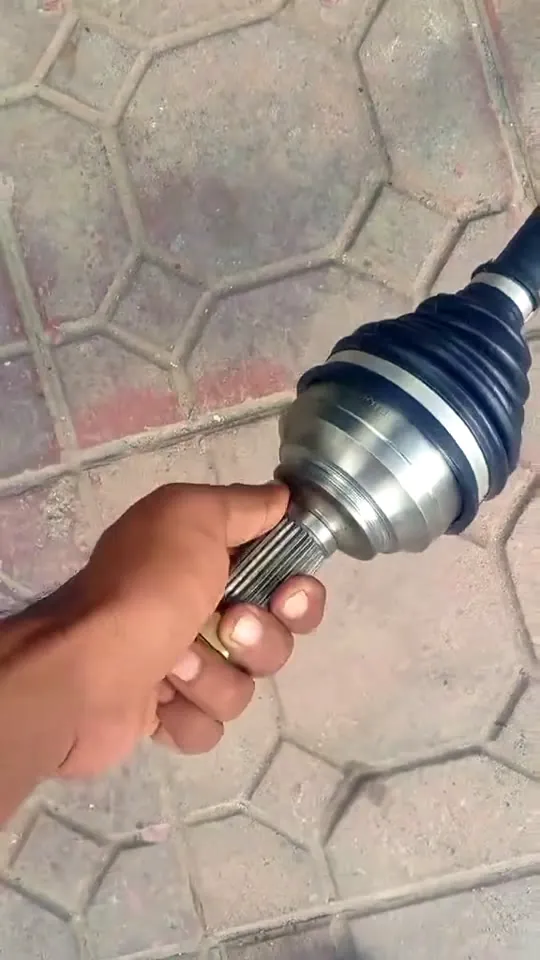 A mechanic holding the old axle kit taken off a Honda City
